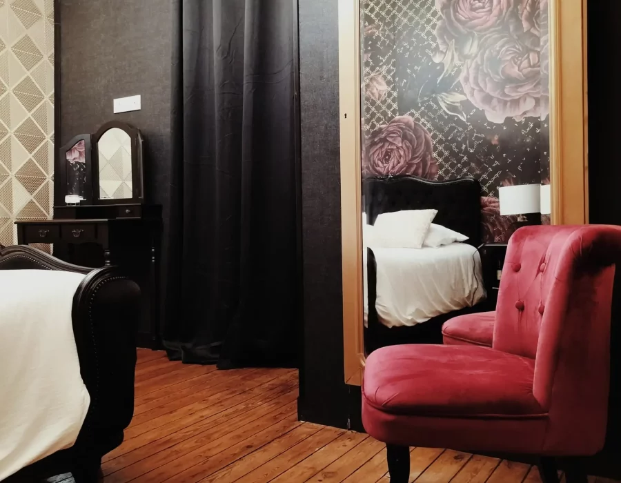 Chambre romantique avec papier peint floral, fauteuil rouge et coiffeuse, Love Room LW House en Vendée
