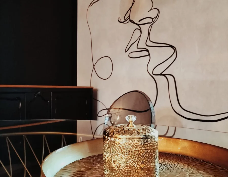 Bougeoir décoratif sur table basse dorée avec sculpture murale minimaliste, LW House