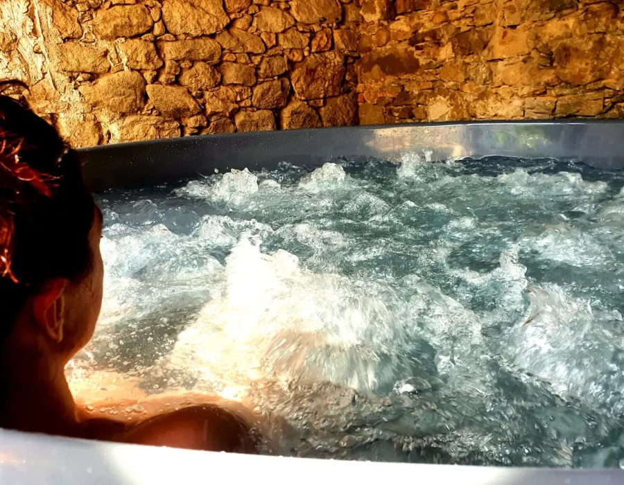 Personne se relaxant dans un bain nordique bouillonnant en pierre, LW House