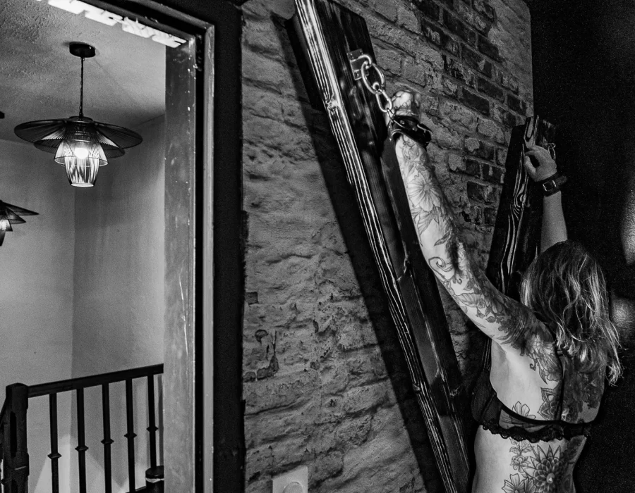 Femme posée près d'un accessoire décoratif suspendu, photo d'ambiance noir et blanc LW House
